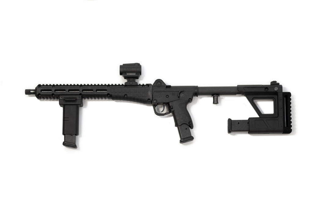 A black tactical PDW with a folding vertical foregrip, adjustable stock, and a mounted optic, shown against a plain white background.