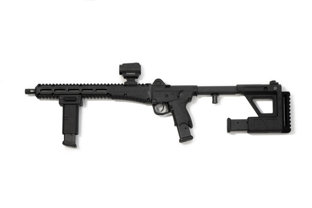A black tactical PDW with a folding vertical foregrip, adjustable stock, and a mounted optic, shown against a plain white background.